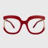 A pair of red glasses featuring elegant gold accents on the frames.