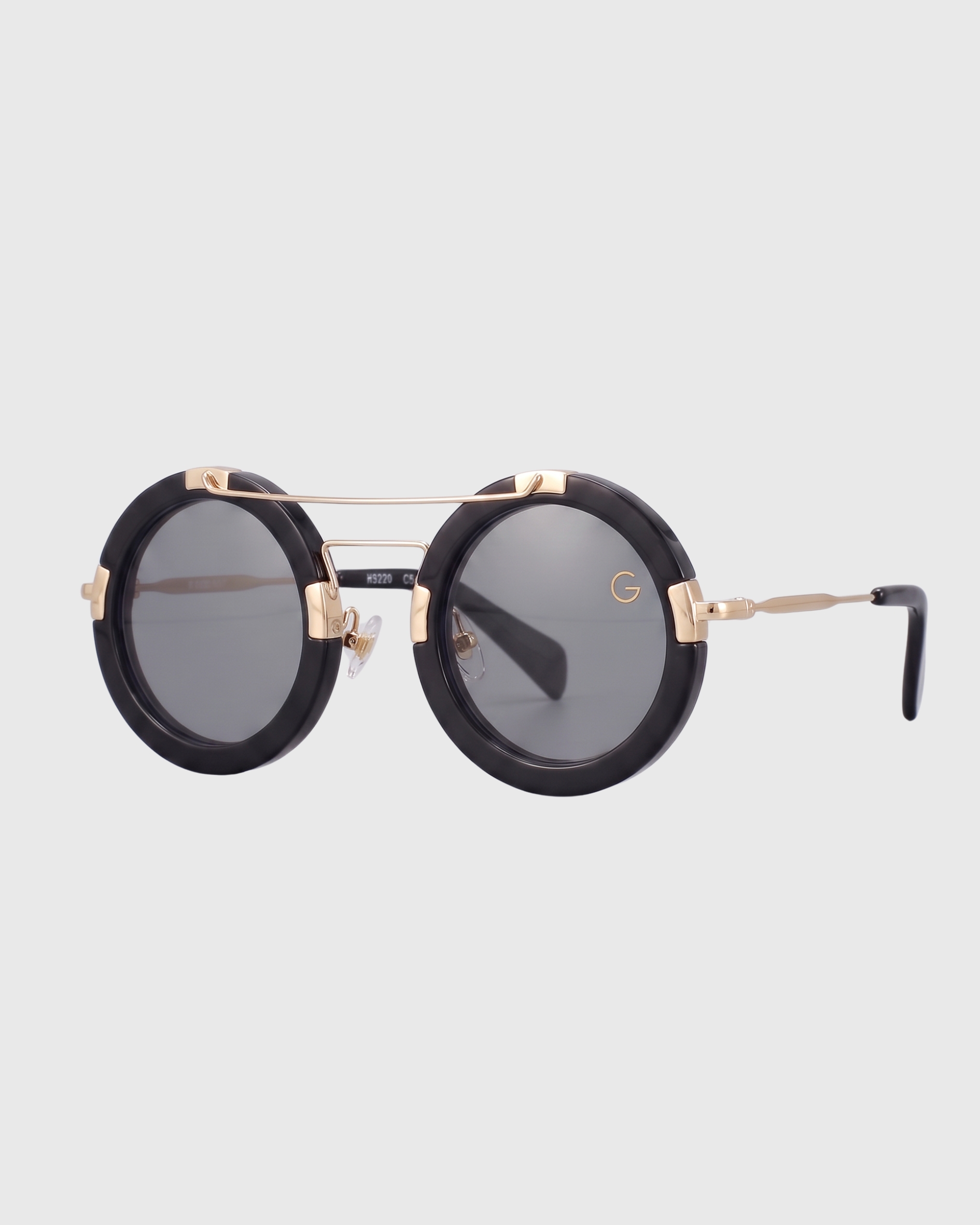Round black plastic sunglasses with gold details, showcasing a stylish and modern design.