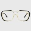 A pair of eyeglasses featuring gold frames and black temples, elegantly designed for a stylish look.