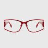 A pair of red glasses resting on a white background, showcasing their vibrant color and stylish design.