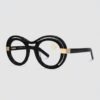 A pair of eyeglasses featuring elegant gold detailing on the temples, set against a neutral background.