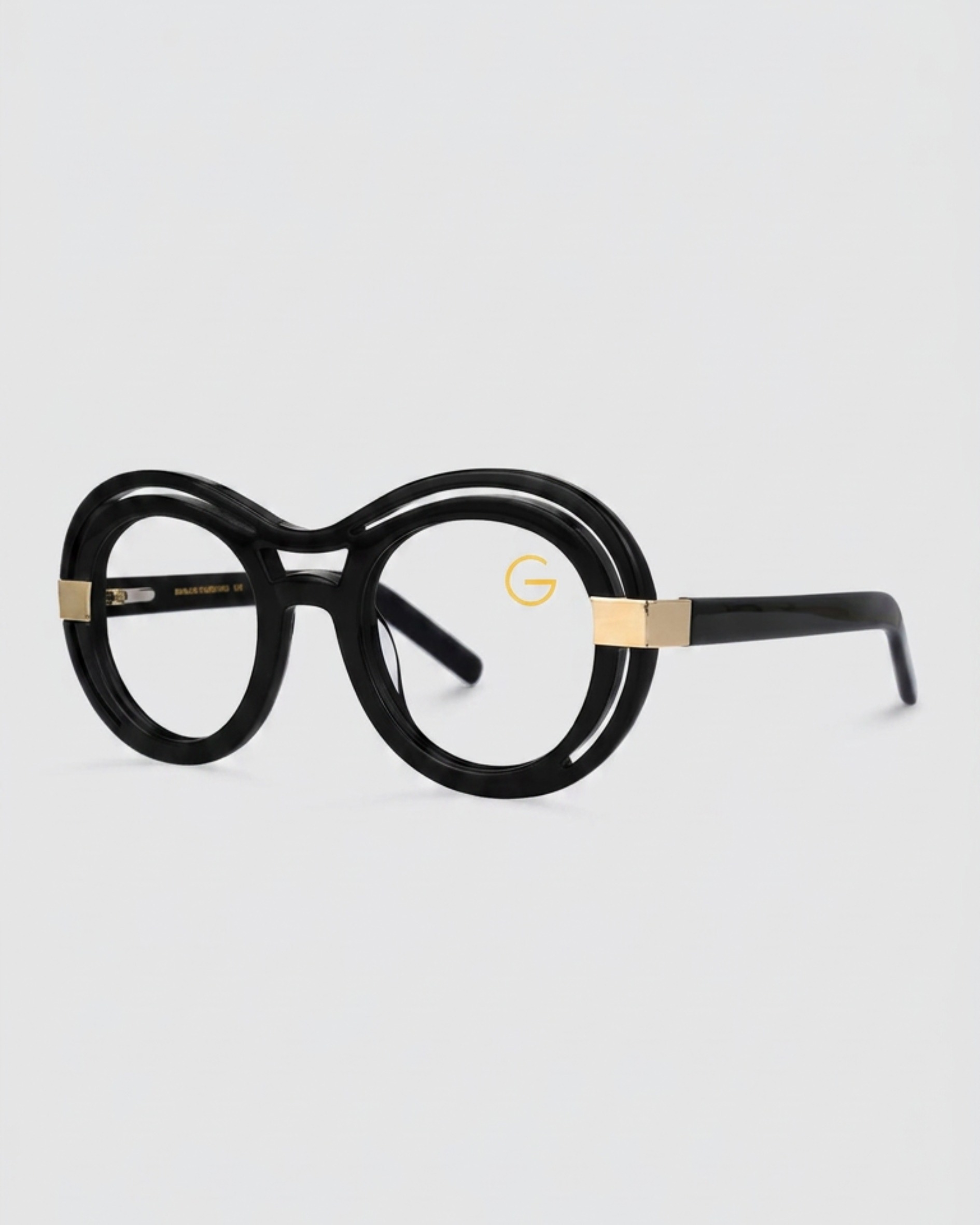 A pair of eyeglasses featuring elegant gold detailing on the temples, set against a neutral background.