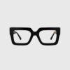 A pair of black glasses featuring elegant gold detailing on the frames.