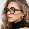 A model showcases stylish leopard print frame glasses, highlighting a trendy eyewear choice.