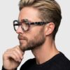 A man wearing glasses featuring a bold leopard print design, showcasing a unique and stylish accessory.