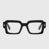 A pair of black glasses featuring elegant gold detailing on the frames.