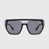 Black sunglasses featuring a gold logo on the side, showcasing a stylish and modern design.
