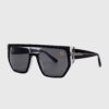 Black sunglasses featuring a gold logo on the side, showcasing a stylish and modern design.